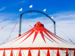 A circus tent under a blue sky with a red and white striped pattern as part of GOTO Creates festival.