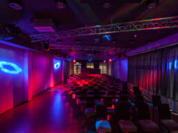 Chairs set up in rows at woodland hotel in a dark, illuminated modern interior at GOTO creates venue Woodland Hotel.