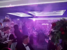 People dancing and seating around tables at corporate event party