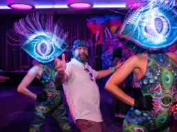 man with bucket hat partying with dancers at corporate event