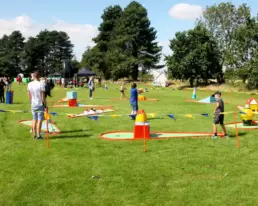 children and adults playing on grass at corporate event